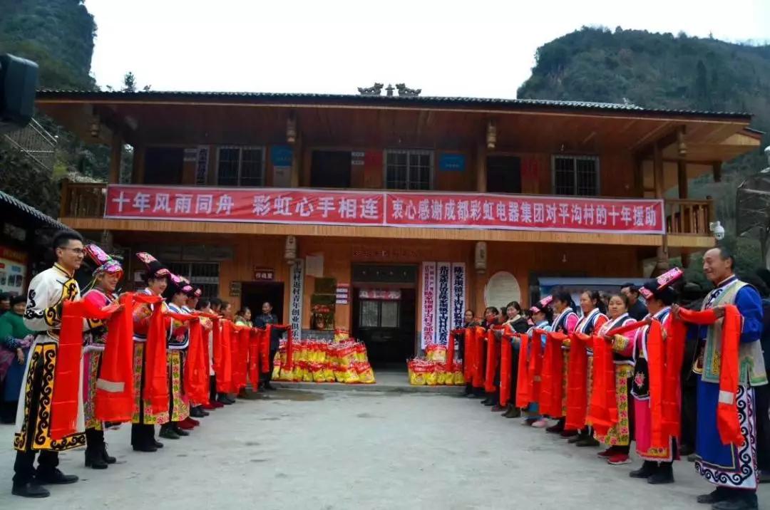 怀感恩之心，平沟村村民手持羌红在MILAN米兰体育·（中国）官方网站公司援建的平沟村便民服务楼前热情等待MILAN米兰体育·（中国）官方网站亲人们的到来